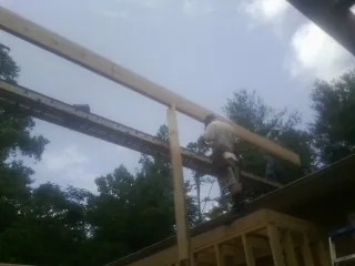 Carpenter setting a ridge beam over a new addition frame — Ice Dam Removal by Roofing Brothers in Sun River