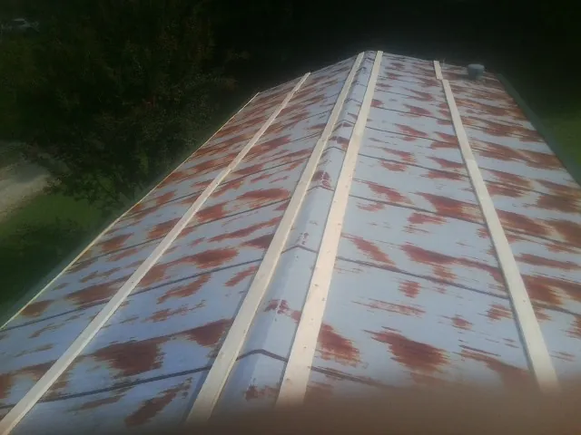 Rusted metal roof panels with new wood purlins before replacement — Storm Damage Roof Repair in Sun River by Roofing Brothers